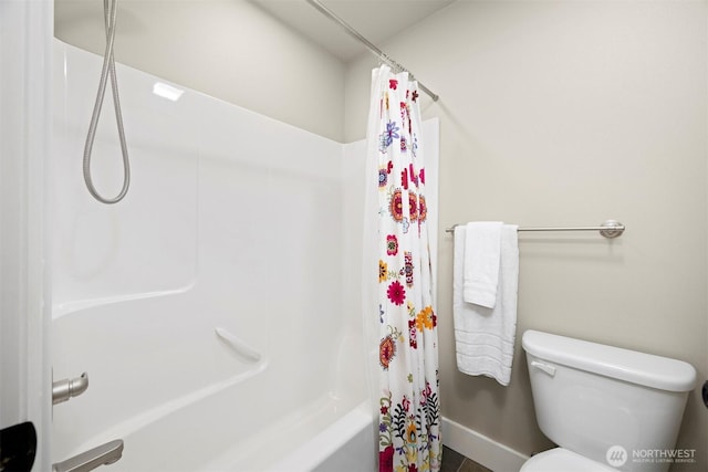 bathroom featuring shower / bath combination with curtain and toilet