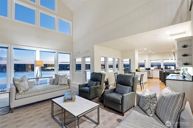 living room with a wealth of natural light, light hardwood / wood-style floors, and a water view