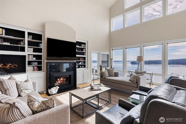 living room featuring baseboard heating, wood-type flooring, and built in features