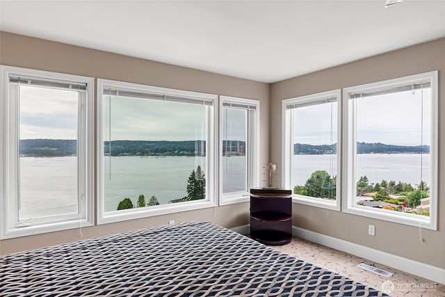 unfurnished bedroom featuring a water view