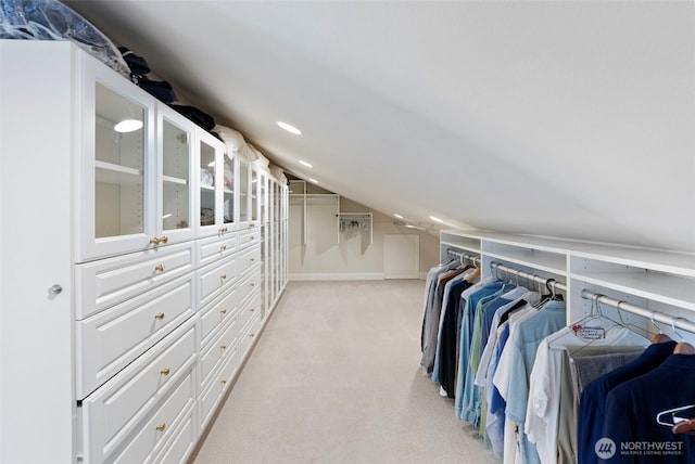 spacious closet featuring vaulted ceiling and light carpet