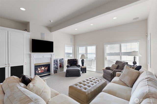 carpeted living room with beam ceiling, plenty of natural light, and a fireplace