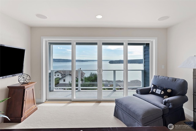 living room with carpet and a water view