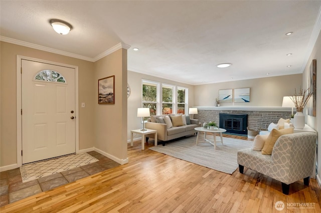 foyer entrance featuring crown molding, a fireplace, and light wood-type flooring