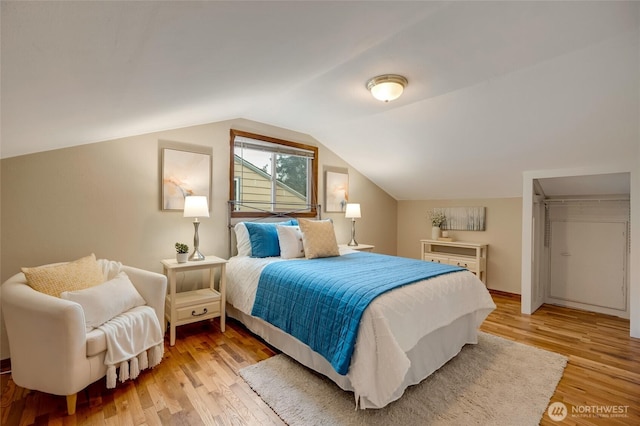 bedroom with lofted ceiling and light hardwood / wood-style flooring