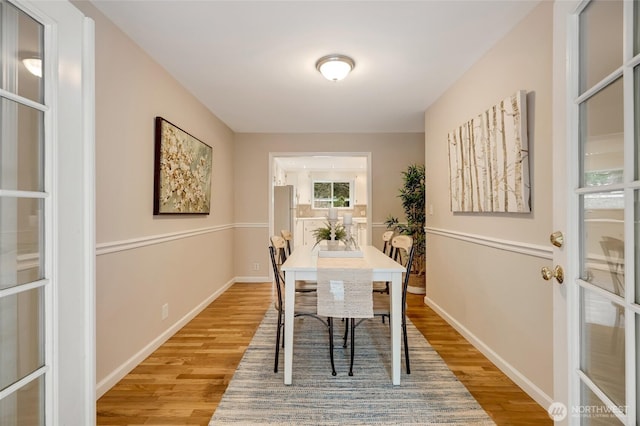 dining area featuring light wood-type flooring and french doors