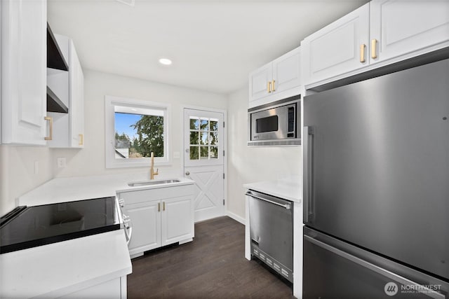 kitchen featuring appliances with stainless steel finishes, dark hardwood / wood-style floors, sink, and white cabinets