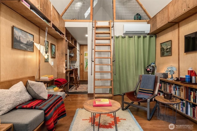 interior space featuring a wall unit AC, a high ceiling, and wood finished floors