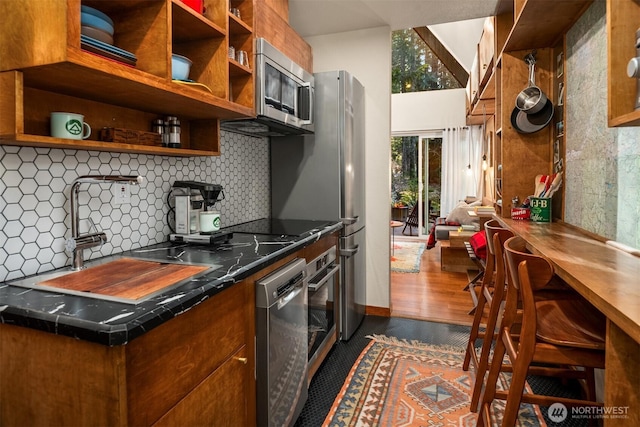 kitchen featuring open shelves, brown cabinetry, appliances with stainless steel finishes, and a sink