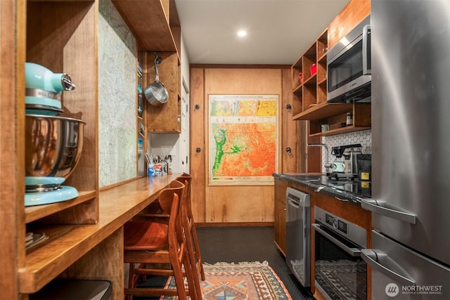 interior space with concrete floors, decorative backsplash, and appliances with stainless steel finishes