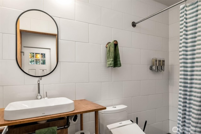 bathroom featuring toilet, tile walls, a shower with curtain, and a sink