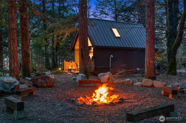 exterior space with metal roof, a fire pit, and a standing seam roof