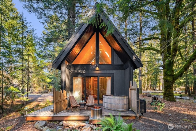 back of property featuring a wooden deck and an outdoor structure