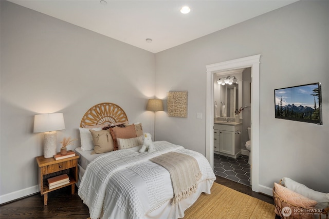 bedroom with ensuite bath and dark hardwood / wood-style flooring