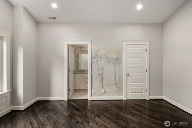 unfurnished bedroom with connected bathroom and dark hardwood / wood-style flooring