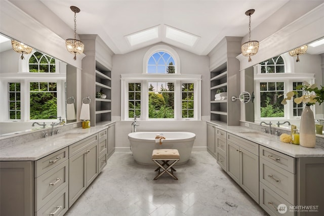 bathroom with vanity, vaulted ceiling with skylight, tile walls, and a washtub