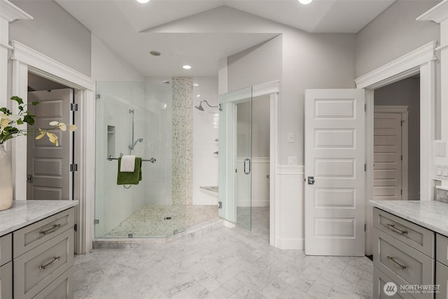 bathroom with vanity, a shower with door, and lofted ceiling