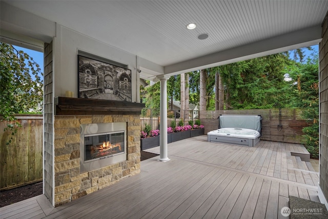 wooden terrace with an outdoor stone fireplace