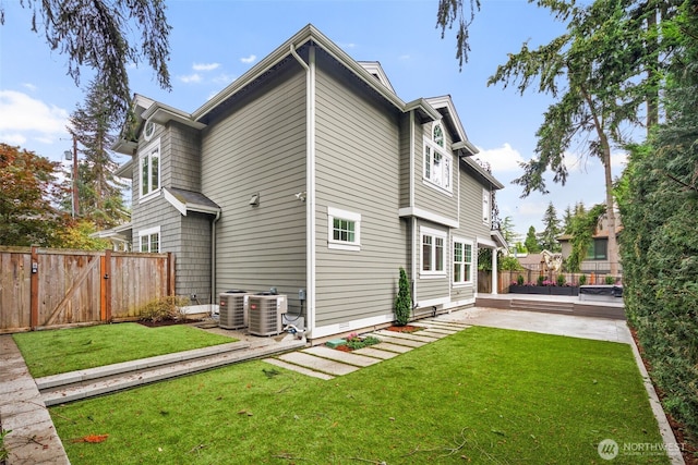 view of property exterior with a yard, a patio area, and central air condition unit