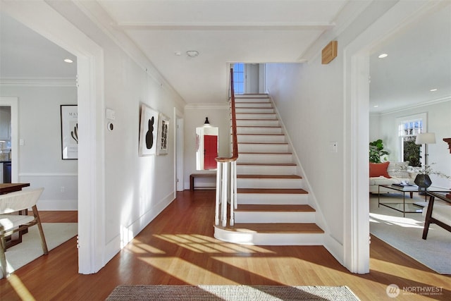 stairway with hardwood / wood-style floors and ornamental molding