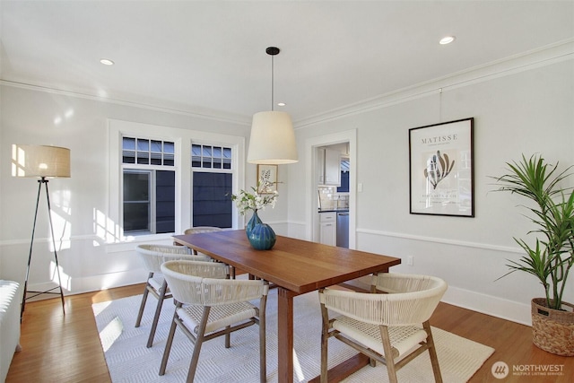 dining room with dark wood-type flooring and crown molding