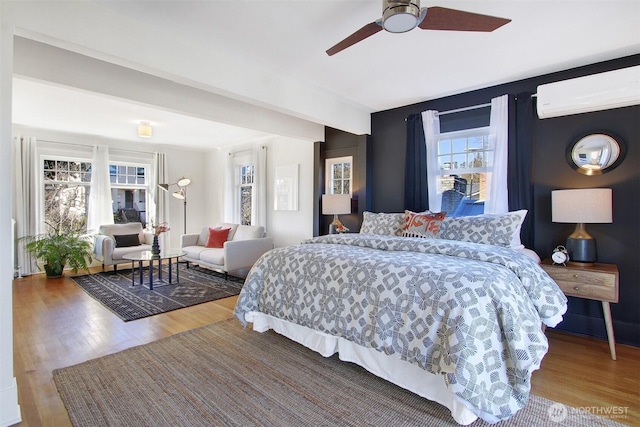 bedroom featuring hardwood / wood-style floors, ceiling fan, a wall mounted air conditioner, and beam ceiling