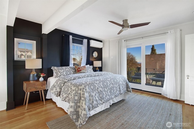 bedroom with a wall unit AC, hardwood / wood-style flooring, beamed ceiling, and access to outside