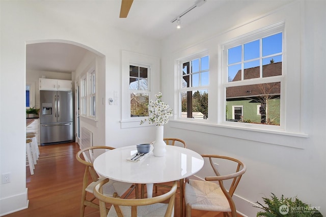 dining space with track lighting and hardwood / wood-style flooring