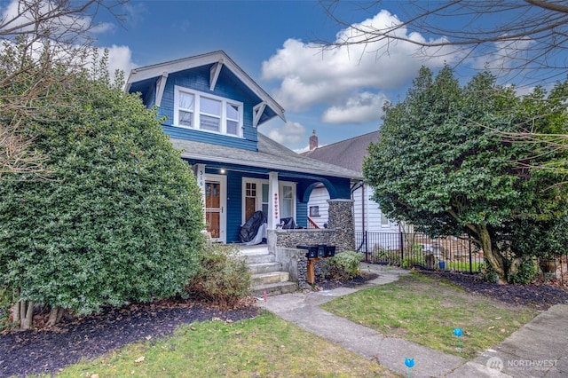 view of front of house with a front yard and covered porch