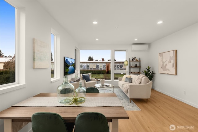 living room featuring a wall mounted air conditioner and light hardwood / wood-style floors