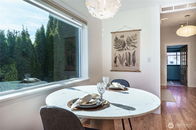 dining space featuring hardwood / wood-style flooring and a notable chandelier