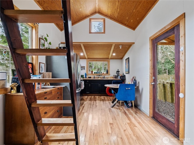 interior space with light hardwood / wood-style flooring, vaulted ceiling, and wooden ceiling