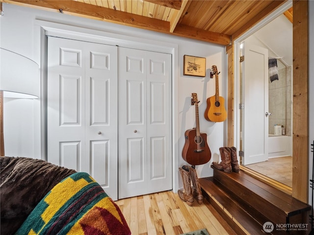 bedroom with wood ceiling, a closet, beamed ceiling, and light wood-type flooring