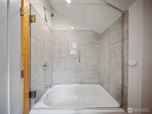 bathroom featuring shower / bath combination with glass door and vaulted ceiling