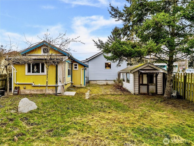 back of house with a yard and a storage unit