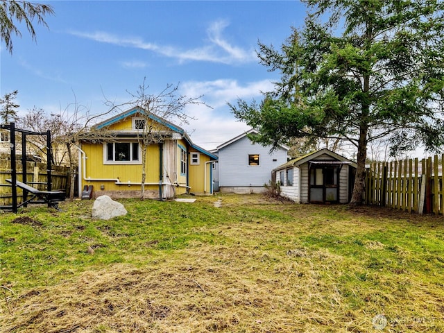 rear view of property with a shed and a lawn