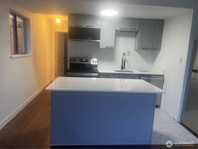 kitchen featuring sink, dark wood-type flooring, gray cabinetry, stainless steel appliances, and a kitchen island