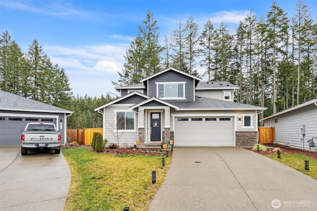 view of front facade with driveway, a garage, stone siding, fence, and a front yard