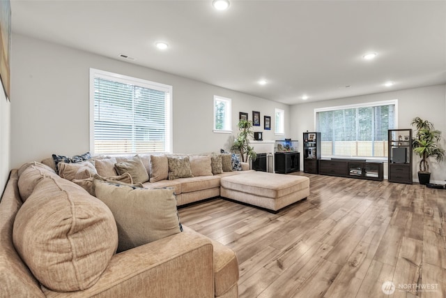 living area featuring light wood-type flooring, visible vents, and recessed lighting