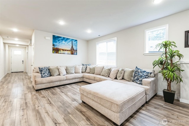 living room with light wood-type flooring, a healthy amount of sunlight, baseboards, and recessed lighting