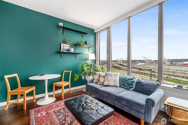 living room with dark wood finished floors, plenty of natural light, and baseboards