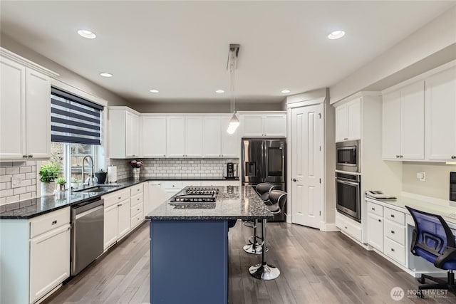 kitchen featuring stainless steel appliances, a center island, and white cabinets