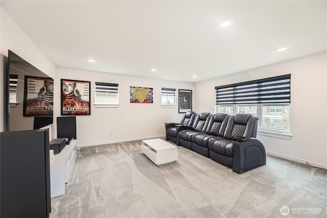 living room featuring light carpet, a healthy amount of sunlight, recessed lighting, and baseboards