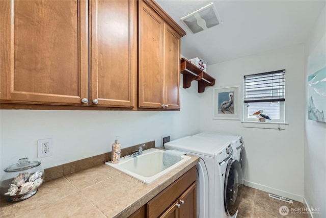 laundry room with cabinet space, visible vents, washing machine and dryer, a sink, and baseboards