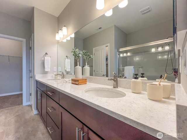 full bathroom with double vanity, a sink, and a walk in closet