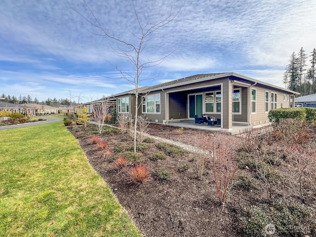 rear view of property featuring a patio area and a lawn