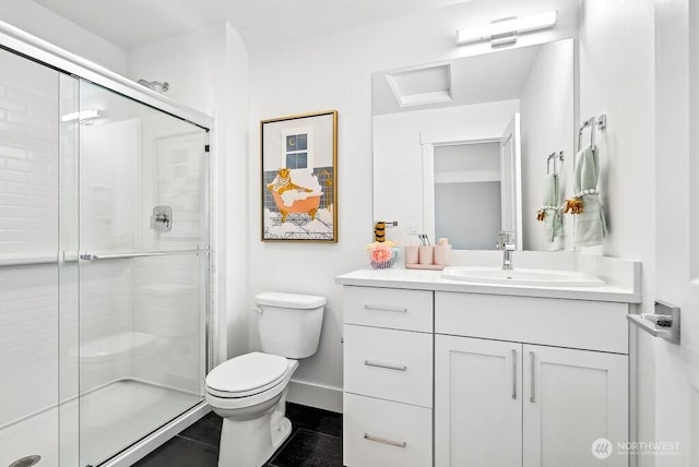 bathroom featuring a shower with shower door, vanity, and toilet