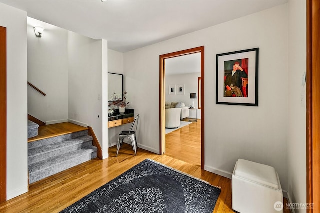 interior space with stairs, baseboards, and wood finished floors