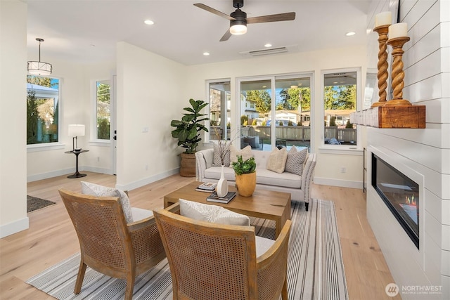 sitting room featuring ceiling fan, a healthy amount of sunlight, and light wood-type flooring