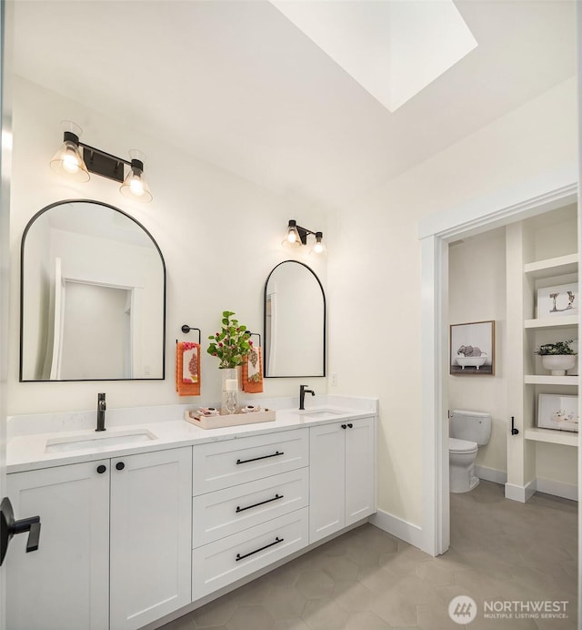 bathroom featuring a skylight, vanity, and toilet